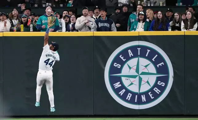 Seattle Mariners center fielder Julio Rodríguez jumps up to make the catch on a line drive by Cincinnati Reds' Spencer Steer during the seventh inning of a baseball game Tuesday, April 16, 2024, in Seattle. (AP Photo/Lindsey Wasson)