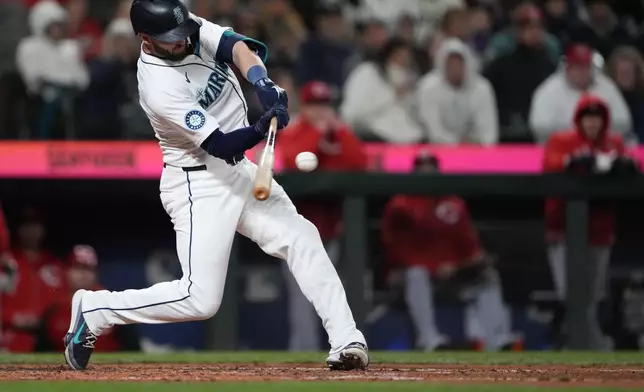 Seattle Mariners' Mitch Haniger hits an RBI single against the Cincinnati Reds during the sixth inning of a baseball game Tuesday, April 16, 2024, in Seattle. (AP Photo/Lindsey Wasson)
