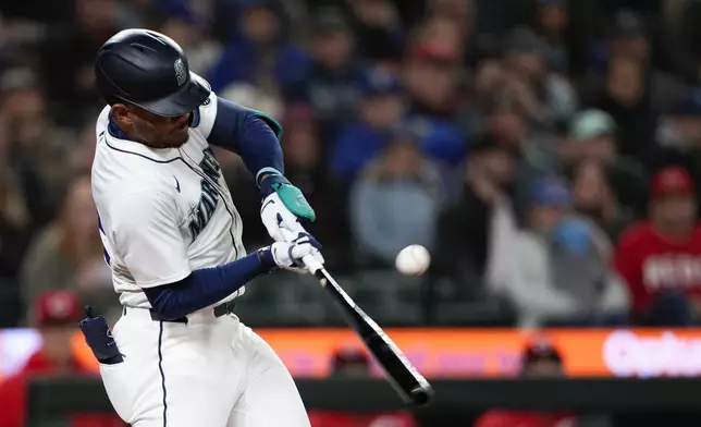 Seattle Mariners' Julio Rodríguez hits a single against the Cincinnati Reds during the seventh inning of a baseball game Monday, April 15, 2024, in Seattle. (AP Photo/Lindsey Wasson)