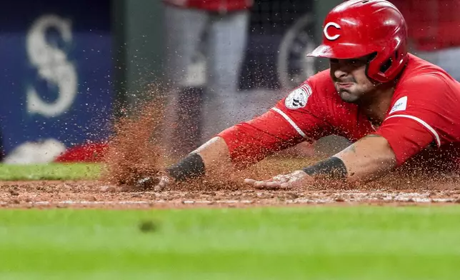 Cincinnati Reds' Christian Encarnacion-Strand slides home to score against the Seattle Mariners on a double by Jake Fraley during the fourth inning of a baseball game Monday, April 15, 2024, in Seattle. (AP Photo/Lindsey Wasson)