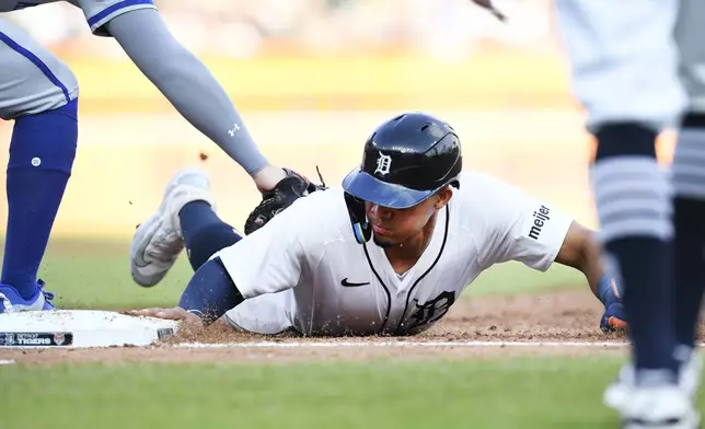 Detroit Tigers' Wenceel Pérez slides safely back to first base before the tag of Kansas City Royals first baseman Vinnie Pasquantino during the third inning of a baseball game Saturday, April 27, 2024, in Detroit. (AP Photo/Jose Juarez)