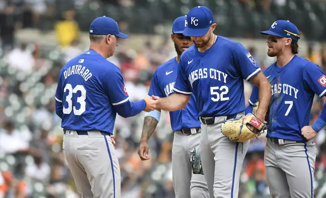 Kansas City Royals manager Matt Quatraro, left, takes the ball away from starting pitcher Michael Wacha (52) after Wacha gave up a home run to Detroit Tigers' Jake Rogers in the sixth inning of a baseball game, Sunday, April 28, 2024, in Detroit. (AP Photo/Jose Juarez)