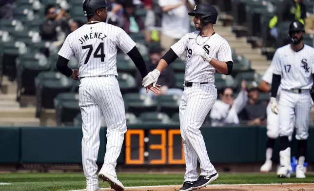 Chicago White Sox's Paul DeJong, right, slaps hands with Eloy Jiménez after DeJong hit a home run during the second inning in the first baseball game of a doubleheader against the Kansas City Royals, Wednesday, April 17, 2024, in Chicago. (AP Photo/Erin Hooley)