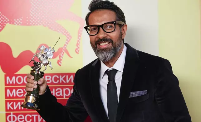 Bangladeshi film director Asif Islam holds the Silver Saint George trophy in the main competition for his film Nirvana, as he poses for a photo after the closing ceremony of the 46th Moscow International Film Festival in Moscow, Russia, on Friday, April 26, 2024. (AP Photo/Alexander Zemlianichenko)