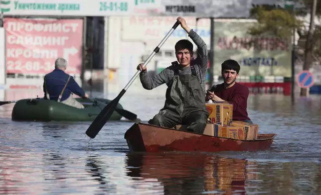 Two men ride a boat as they deliver food in a flooded area in Orenburg, Russia, on Thursday, April 11, 2024. Russian officials are scrambling to help homeowners displaced by floods, as water levels have risen in the Ural River. The river's water level in the city of Orenburg was above 10 meters (33 feet) Wednesday, state news agency Ria Novosti reported, citing the regional governor. (AP Photo)