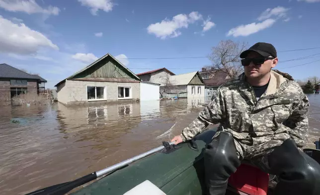 A man rides his rubber boat to help local residents during evacuations from a flooded area in Orenburg, Russia, on Thursday, April 11, 2024. Russian officials are scrambling to help homeowners displaced by floods, as water levels have risen in the Ural River. The river's water level in the city of Orenburg was above 10 meters (33 feet) Wednesday, state news agency Ria Novosti reported, citing the regional governor. (AP Photo)