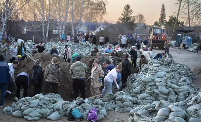 Local residents and volunteers prepare sandbags to strengthen the dam toward a flooded area in Ishim, Tyumen region, 1968 km (1230 miles) east of Moscow, Russia, on Sunday, April 21, 2024. The situation with floods in Russia's Tyumen Region remains tense, with the level of water in the Ishim River having exceeded 10.5 meters, (AP Photo/Sergei Rusanov)