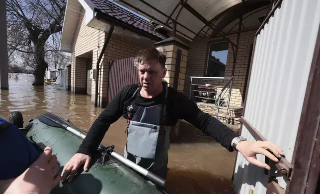 A man prepares to ride his rubber boat to help local residents during evacuations from a flooded area in Orenburg, Russia, on Thursday, April 11, 2024. Russian officials are scrambling to help homeowners displaced by floods, as water levels have risen in the Ural River. The river's water level in the city of Orenburg was above 10 meters (33 feet) Wednesday, state news agency Ria Novosti reported, citing the regional governor. (AP Photo)