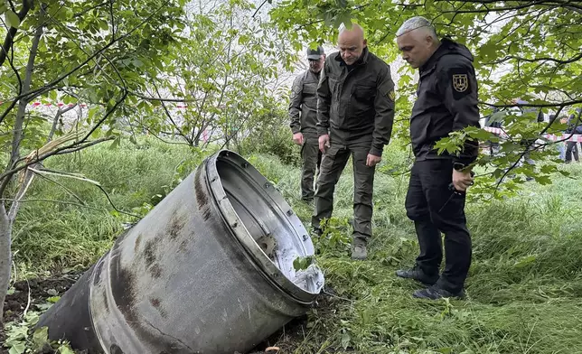 In this photo provided by the Odesa Regional Administration, city officials examine a fragment of a missile after the Russian missile attack that killed several people, and wounded multiple others in Odessa, Ukraine, Monday, April 29, 2024. (Odesa Regional Administration via AP)