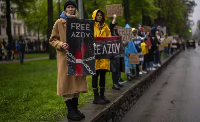 Women hold "Free Azov" signs during a rally aiming to raise awareness on the fate of Ukrainian prisoners of war in Kyiv, Ukraine, Sunday, April 21, 2024. The U.S. House of Representatives swiftly approved $95 billion in foreign aid for Ukraine, Israel and other U.S. allies in a rare Saturday session as Democrats and Republicans banded together after months of hard-right resistance over renewed American support for repelling Russia's invasion. (AP Photo/Francisco Seco)