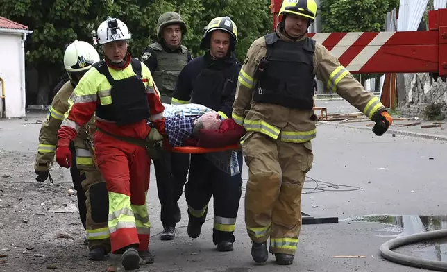 In this photo provided by the Ukrainian Emergency Service, rescuers and ambulance workers carry a person at the scene of a Russian attack in Dnipro, Ukraine, Friday, April 19, 2024. (Ukrainian Emergency Service via AP Photo)