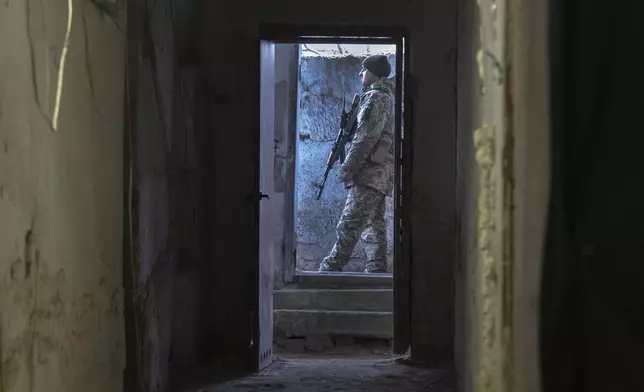 FILE - A Ukrainian soldier stands outside a shelter in the front-line city of Kupiansk, Kharkiv region, Ukraine, Thursday, Nov. 30, 2023. Approval by the U.S. House of a $61 billion package for Ukraine puts the country a step closer to getting an infusion of new firepower. But the clock is ticking. Russia is using all its might to achieve its most significant gains since the invasion by a May 9 deadline. (AP Photo/Efrem Lukatsky, File)