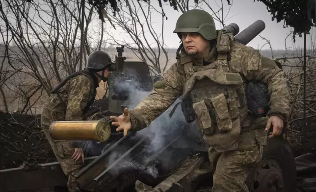 FILE - Ukrainian soldiers with the 71st Jaeger Brigade fire a M101 howitzer at Russian positions on the front line, near the city of Avdiivka in Ukraine's Donetsk region, on March 22, 2024. Approval by the U.S. House of a $61 billion package for Ukraine puts the country a step closer to getting an infusion of new firepower. But the clock is ticking. Russia is using all its might to achieve its most significant gains since the invasion by a May 9 deadline. (AP Photo/Efrem Lukatsky, File)