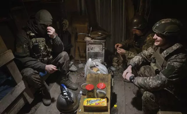 FILE - Ukrainian soldiers of the 71st Jaeger Brigade chat in a shelter at the frontline, near Avdiivka, Donetsk region, Ukraine, Friday, March 22, 2024. Approval by the U.S. House of a $61 billion package for Ukraine puts the country a step closer to getting an infusion of new firepower. But the clock is ticking. Russia is using all its might to achieve its most significant gains since the invasion by a May 9 deadline. (AP Photo/Efrem Lukatsky, File)