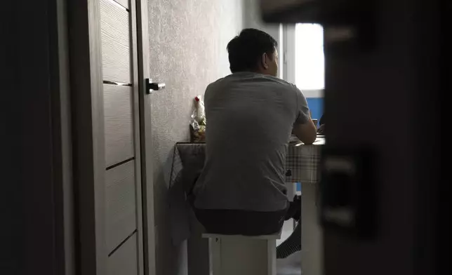 A Russian soldier who goes by the nickname Sparrow sits at his kitchen table in his apartment in Astana, Kazakhstan, in late 2023. After being forcibly conscripted, he ran away from his barracks because he didn't want to kill anyone. "I don't want anything in life. I have no interest in my own affairs," he said. "I just sit all day on the Internet, on YouTube, and read news, news, news of what's going on in Ukraine, and that's it." (AP Photo)