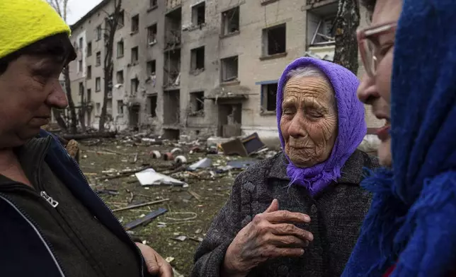 FILE - Olha Faichuk, 79, center, cries as she says goodbye to her neighbors in front of her apartment building, which was heavily damaged by a Russian airstrike, in Lukiantsi, Kharkiv region, Ukraine, on Tuesday, April 16, 2024. (AP Photo/Evgeniy Maloletka, File)