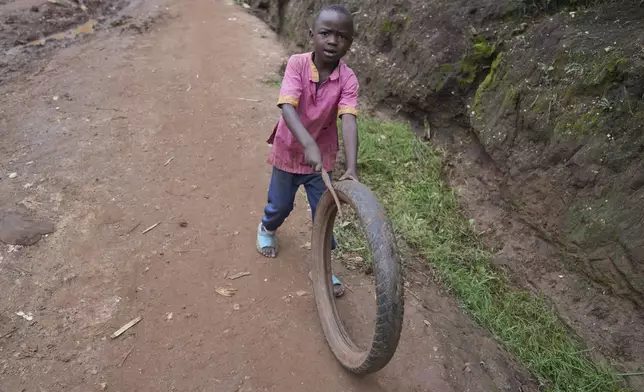 A young Rwandan boy plays with a tyre in Gahanga the outskirts of Kigali, Rwanda, Tuesday, April 4, 2024. The country will commemorate on April 7, 2024 the 30th anniversary of the genocide when ethnic Hutu extremists killed neighbours, friends and family during a three-month rampage of violence aimed at ethnic Tutsis and some moderate Hutus, leaving a death toll that Rwanda puts at 1,000,050. (AP Photo/Brian Inganga)