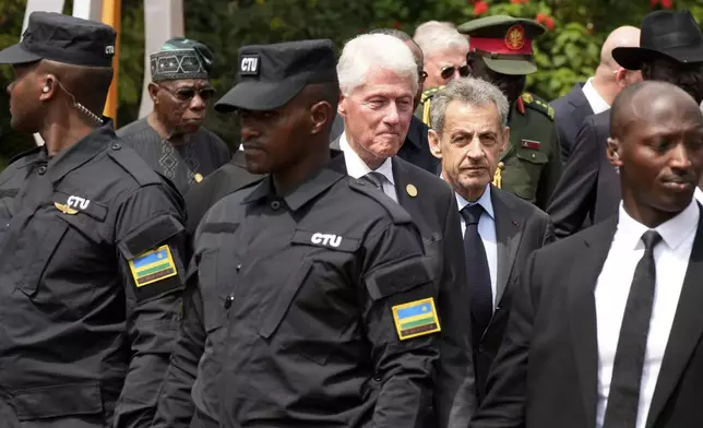 Former US President Bill Clinton, center left, and former President of France Nicolas Sarkozy, center right, leave after laying a wreath at the Kigali Genocide Memorial, in Kigali, Rwanda, Sunday, April 7, 2024. Rwandans are commemorating 30 years since the genocide in which an estimated 800,000 people were killed by government-backed extremists, shattering this small east African country that continues to grapple with the horrific legacy of the massacres. (AP Photo/Brian Inganga)