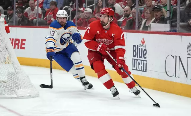 Detroit Red Wings center Dylan Larkin (71) looks to pass as Buffalo Sabres right wing Lukas Rousek (13) defends in the second period of an NHL hockey game Sunday, April 7, 2024, in Detroit. (AP Photo/Paul Sancya)