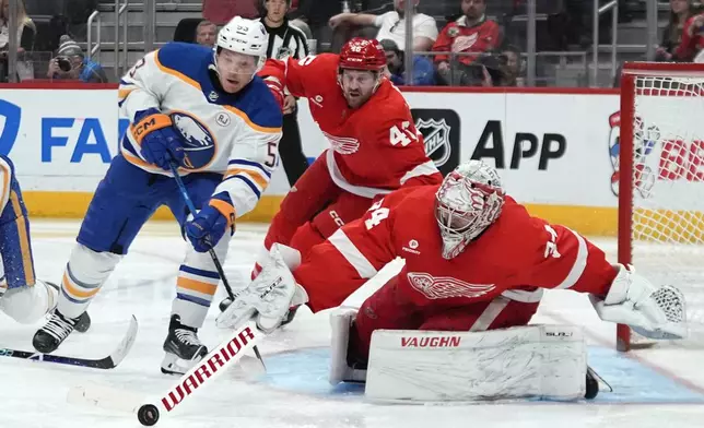 Detroit Red Wings goaltender Alex Lyon (34) stops a Buffalo Sabres left wing Jeff Skinner (53) shot as Jeff Petry (46) defends in the second third of an NHL hockey game Sunday, April 7, 2024, in Detroit. (AP Photo/Paul Sancya)