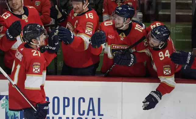 Teammates congratulate Florida Panthers center Nick Cousins (21) after he scored a goal during the first period of an NHL hockey game against the Ottawa Senators, Tuesday, April 9, 2024, in Sunrise, Fla. (AP Photo/Marta Lavandier)