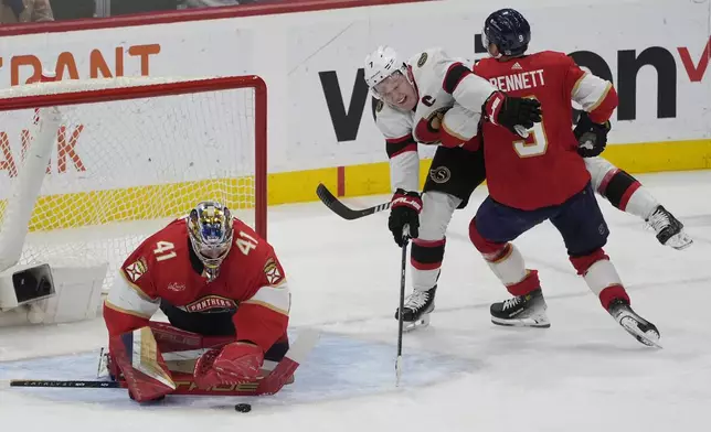 Florida Panthers goaltender Anthony Stolarz (41) stops a shot on goal by Ottawa Senators left wing Brady Tkachuk (7) as center Sam Bennett (9) defends during the second period of an NHL hockey game, Tuesday, April 9, 2024, in Sunrise, Fla. (AP Photo/Marta Lavandier)