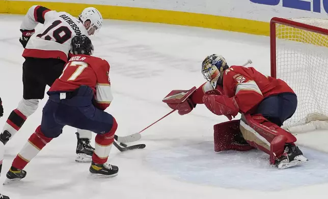 Florida Panthers defenseman Niko Mikkola (77) defends Ottawa Senators right wing Drake Batherson (19) and goaltender Anthony Stolarz (41) tries to stop a shot on goal during the first period of an NHL hockey game, Tuesday, April 9, 2024, in Sunrise, Fla. (AP Photo/Marta Lavandier)