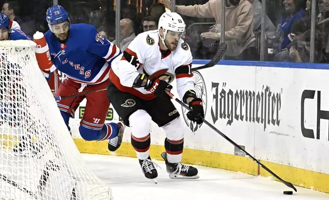 Ottawa Senators left wing Jiri Smejkal (13) skates with the puck as he is pursued by New York Rangers defenseman K'Andre Miller (79) during the first period of an NHL hockey game Monday, April 15, 2024, at Madison Square Garden in New York. (AP Photo/Bill Kostroun)
