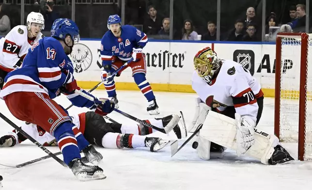 Ottawa Senators goaltender Joonas Korpisalo (70) stops a shot by New York Rangers left wing Alexis Lafrenière (13) during the second period of an NHL hockey game Monday, April 15, 2024, at Madison Square Garden in New York. (AP Photo/Bill Kostroun)