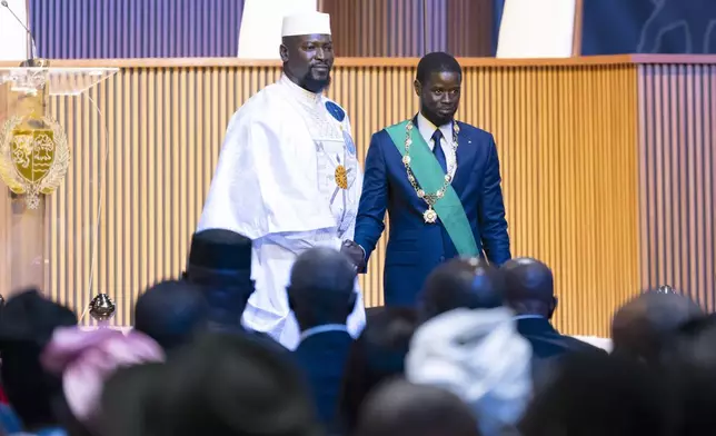 Bassirou Diomaye Faye, right, greets Guinea's interim president Mamadi Doumbouya during his swearing in ceremony as Senegal's president in Dakar, Senegal, Tuesday, April 2, 2024. Senegal has sworn in Bassirou Diomaye Faye as its new president, completing the previously little-known opposition figure’s dramatic ascent from prison to the palace in recent weeks. Faye was released from prison less than two weeks before the March election following a political amnesty announced by the outgoing president. (AP Photo/Sylvain Cherkaoui)