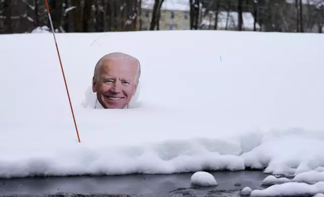 A cutout of President Biden is surrounded by snow next to the driveway of a home, Friday, April 5, 2024, in Derry, N.H. Many New Englanders are cleaning up following a major spring storm on Thursday that brought heavy snow, rain and high winds to the Northeast. Hundreds of thousands of homes and businesses are still without power in Maine and New Hampshire. (AP Photo/Charles Krupa)