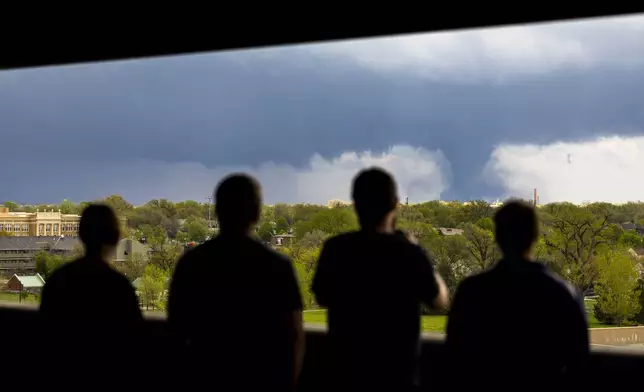 From left; Ally Mercer, Gabe Sedlacek Kaleb Andersen and Austin Young watch a tornado from a seventh floor parking garage on Friday, April 26, 2024, in Lincoln, Neb. (Kenneth Ferriera/Lincoln Journal Star via AP)