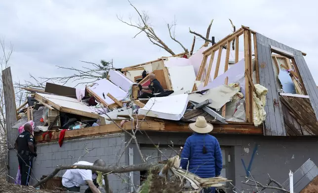 Omaha police officers search a home for a family after a tornado leveled dozens of homes near Omaha, Neb., on Friday, April 26, 2024. (Nikos Frazier/Omaha World-Herald via AP)