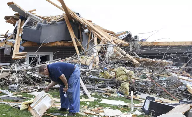 Terry Kicking sifts through the damage after a tornado leveled his home, Friday, April 26, 2024, in Omaha, Neb. (Nikos Frazier/Omaha World-Herald via AP)