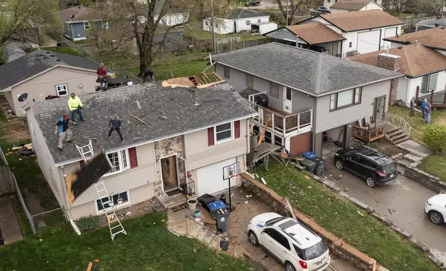 Neighbors help clean up Justin and Amanda Putnam's home after a severe storm blew through the area in Council Bluffs, Iowa, on Friday, April 26, 2024. (Anna Reed/Omaha World-Herald via AP)