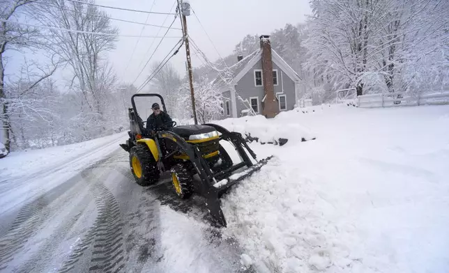 David Herrick of Townshend, Vt., uses a tractor to remove the snow from his driveway on Thursday, April 4, 2024. (Kristopher Radder/The Brattleboro Reformer via AP)