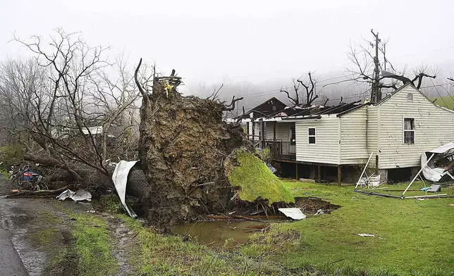 A tree sits uprooted and the roof is ripped off a home belonging to Johnny Carte on Lookout Road in Hico, W.Va., Wednesday, April 3, 2024, after a storm hit the area the day before. (Rick Barbero/The Register-Herald via AP)