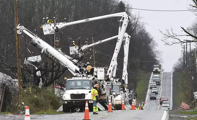 Crews work on utility lines along Route 60 in Hico, W.Va., Wednesday, April 3, 2024. The lines were damaged by a storm that hit the area the day before. (Rick Barbero/The Register-Herald via AP)