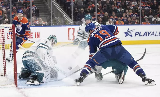 San Jose Sharks goalie Devin Cooley (1) makes the save on Edmonton Oilers' Adam Henrique (19) during the second period of an NHL hockey game in Edmonton, Alberta, on Monday, April 15, 2024. (Jason Franson/The Canadian Press via AP)