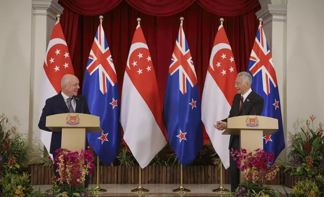 In this photo released by Singapore's Ministry of Communications and Information, New Zealand Prime Minister Luxon, left, chats with Singapore's Prime Minister Lee Hsien Loong during a news conference at the Istana, Monday, April 15, 2024. (Terence Tan/Ministry of Communications and Information via AP)