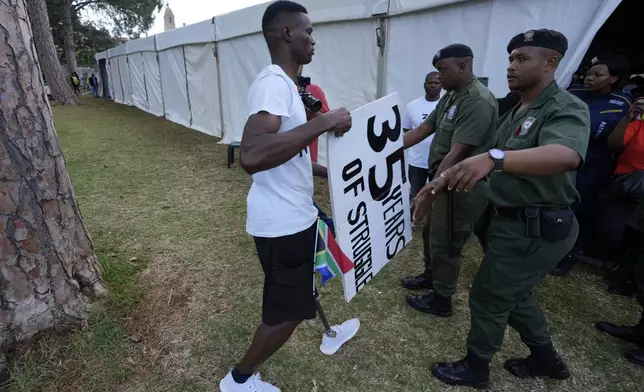 A protester is apprehended as he attends Freedom Day celebrations in Pretoria, South Africa, Saturday April 27, 2024. The day marks April 27 when the country held pivotal first democratic election in 1994 that announced the official end of the racial segregation and oppression of apartheid. (AP Photo/Themba Hadebe)