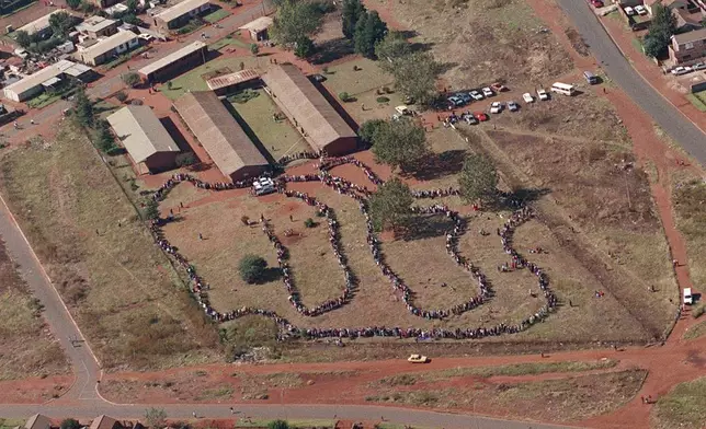 FILE - People queue to cast their votes In Soweto, South Africa April 27, 1994, in the country's first all-race elections. South Africans celebrate "Freedom Day" every April 27, when they remember their country's pivotal first democratic elections in 1994 that announced the official end of the racial segregation and oppression of apartheid. (AP Photo/Denis Farrell. File)