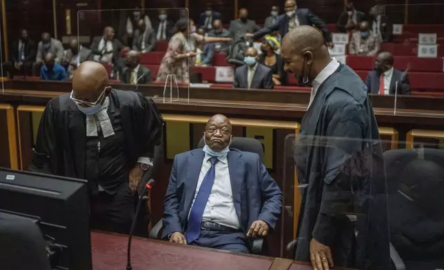 FILE - Former South African President Jacob Zuma, centre, with his legal team in the High Court in Pietermaritzburg, South Africa on Jan. 31, 2022 during a hearing of his corruption trial. For the first time since 1994, the ruling African National Congress (ANC) might receive less than 50% of votes after Zuma stepped down in disgrace in 2018 amid a swirl of corruption allegations and has given his support to the newly-formed UMkhonto WeSiizwe political party. (AP Photo/Jerome Delay, Pool, File)