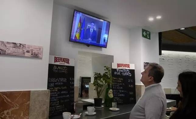 A man watches as Spanish Prime Minister Pedro Sanchez appears on a television broadcast in Madrid, Spain, Monday, April 29, 2024. Sánchez says he will continue in office "even with more strength" after days of reflection. Sánchez shocked the country last week when he said he was taking five days off to think about his future after a court opened preliminary proceedings against his wife on corruption allegations. (AP Photo/Paul White)