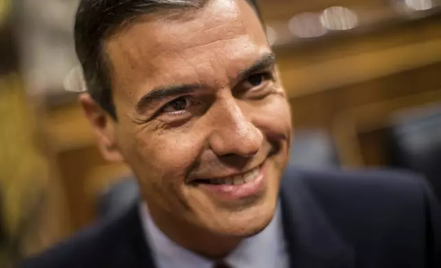 FILE, Spain's caretaker Prime Minister Pedro Sánchez smiles during the parliamentary debate at the Spanish parliament in Madrid, Spain, Monday, July 22, 2019. Sánchez says he will continue in office "even with more strength" after days of reflection. Sánchez shocked the country last week when he said he was taking five days off to think about his future after a court opened preliminary proceedings against his wife on corruption allegations. (AP Photo/Bernat Armangue, File)