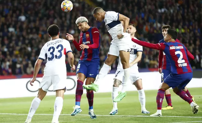 Barcelona's Ronald Araujo, center left, and PSG's Kylian Mbappe go for a header during the Champions League quarterfinal second leg soccer match between Barcelona and Paris Saint-Germain at the Olimpic Lluis Companys stadium in Barcelona, Spain, Tuesday, April 16, 2024. (AP Photo/Joan Monfort)