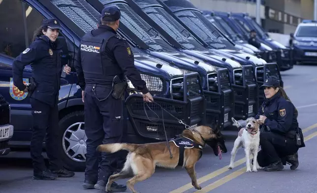 Police officers take positions outside the Santiago Bernabeu stadium, ahead of the Champions League quarterfinal first leg soccer match between Real Madrid and Manchester City in Madrid, Spain, Tuesday, April 9, 2024. This week's Champions League soccer games will go ahead as scheduled despite an Islamic State terror threat. A media outlet linked to the terror group has issued multiple posts calling for attacks at the stadiums hosting quarterfinal matches in Paris, Madrid and London. (AP Photo/Andrea Comas)