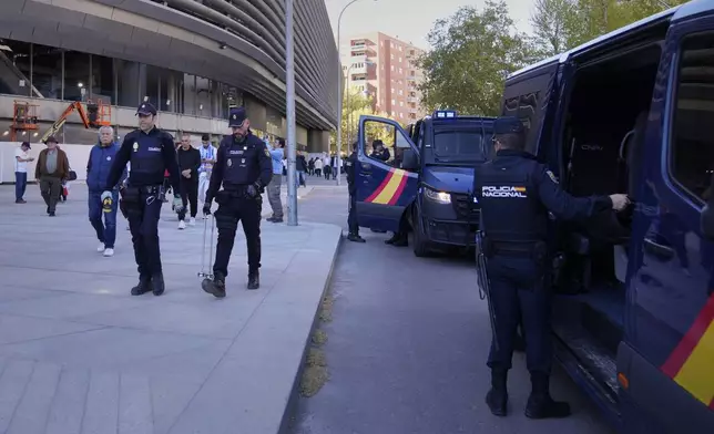 Police officers arrive at the Santiago Bernabeu stadium, ahead of the Champions League quarterfinal first leg soccer match between Real Madrid and Manchester City in Madrid, Spain, Tuesday, April 9, 2024. This week's Champions League soccer games will go ahead as scheduled despite an Islamic State terror threat. A media outlet linked to the terror group has issued multiple posts calling for attacks at the stadiums hosting quarterfinal matches in Paris, Madrid and London. (AP Photo/Manu Fernandez)