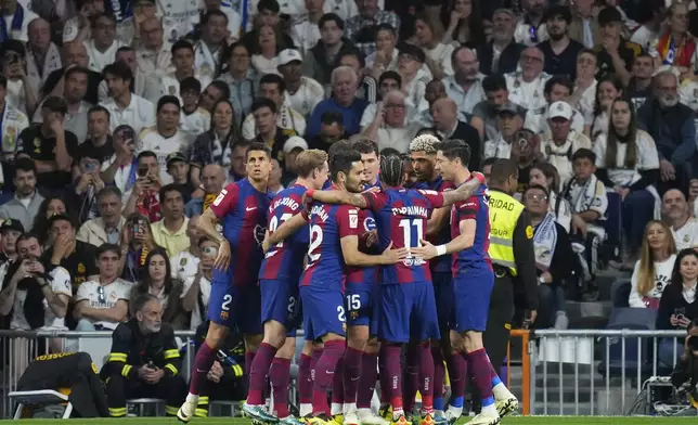 Barcelona players celebrate after their teammate Andreas Christensen, center, scores his side's opening goal during the Spanish La Liga soccer match between Real Madrid and Barcelona at the Santiago Bernabeu stadium in Madrid, Spain, Sunday, April 21, 2024. (AP Photo/Manu Fernandez)