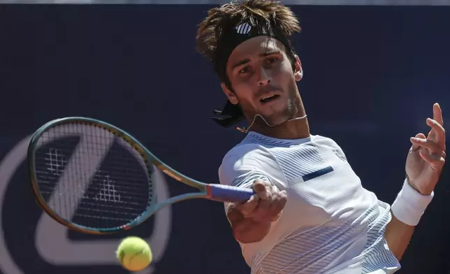 Tomas Martin Etcheverry of Argentina returns the ball against Casper Ruud of Norway during a semi final open tennis tournament in Barcelona, Spain, Saturday, April 20, 2024. (AP Photo/Joan Monfort)